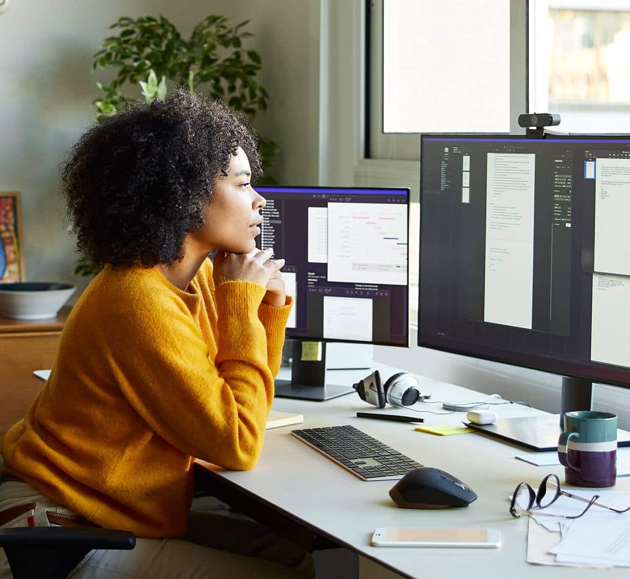 A woman looking at desktop monitors